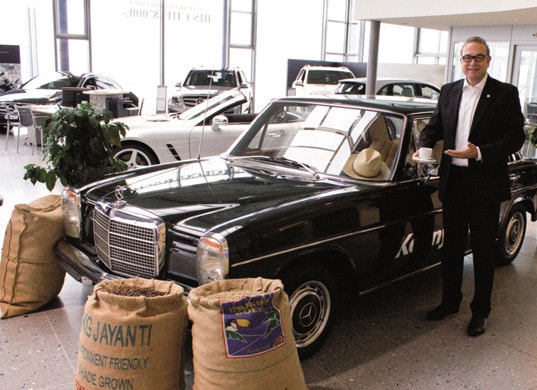 Kenny Eichenberger: Ein TV-Spot zeigt den Inhaber mit einem „feinen Käfeli“ neben einem Mercedes-Benz-Oldtimer 250 E (Baujahr 1970).